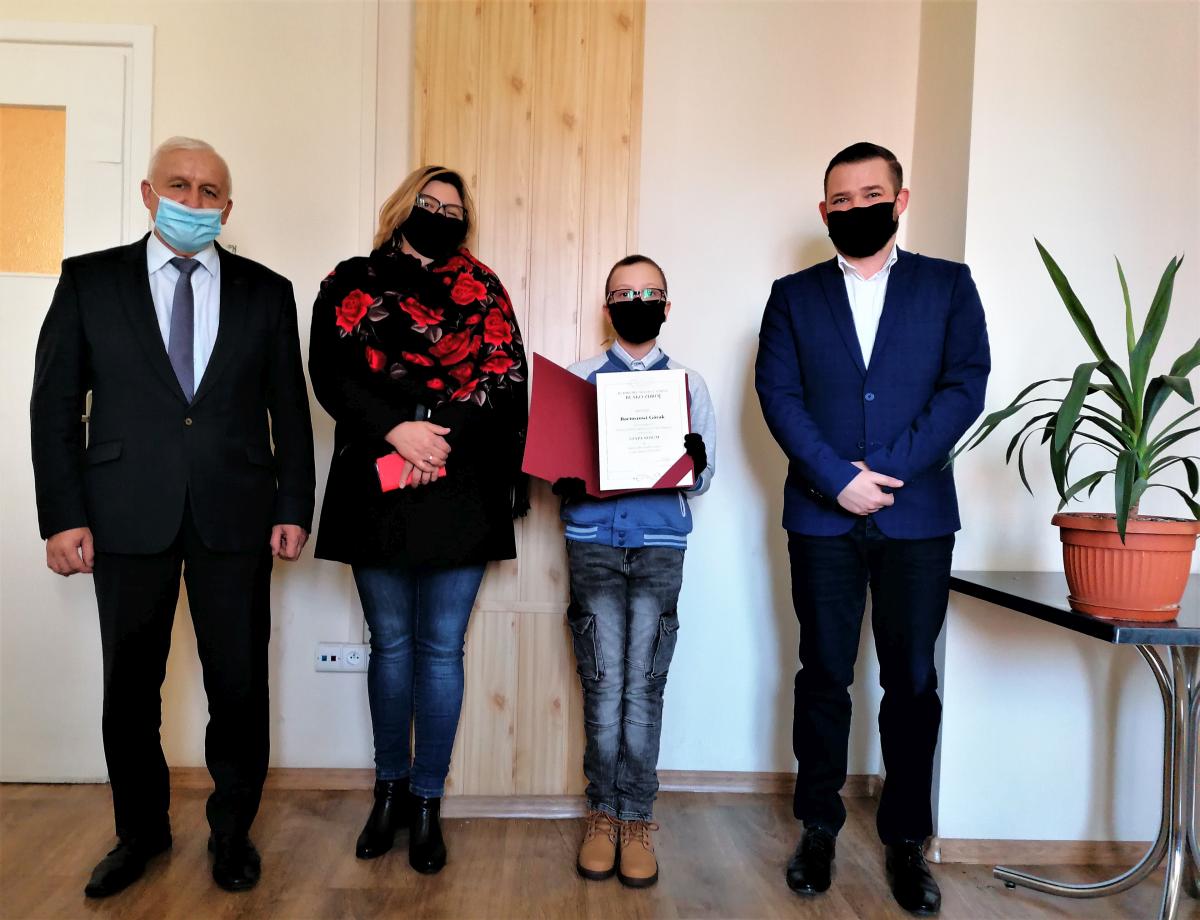 Zdjęcie przedstawia Burmistrza Miasta i Gminy Busko-Zdrój Waldemara Sikorę, Z-cę Burmistrza Miasta i Gminy Busku-Zdrój Michała Marońskiego, Stypendystę  oraz jego mamę.
