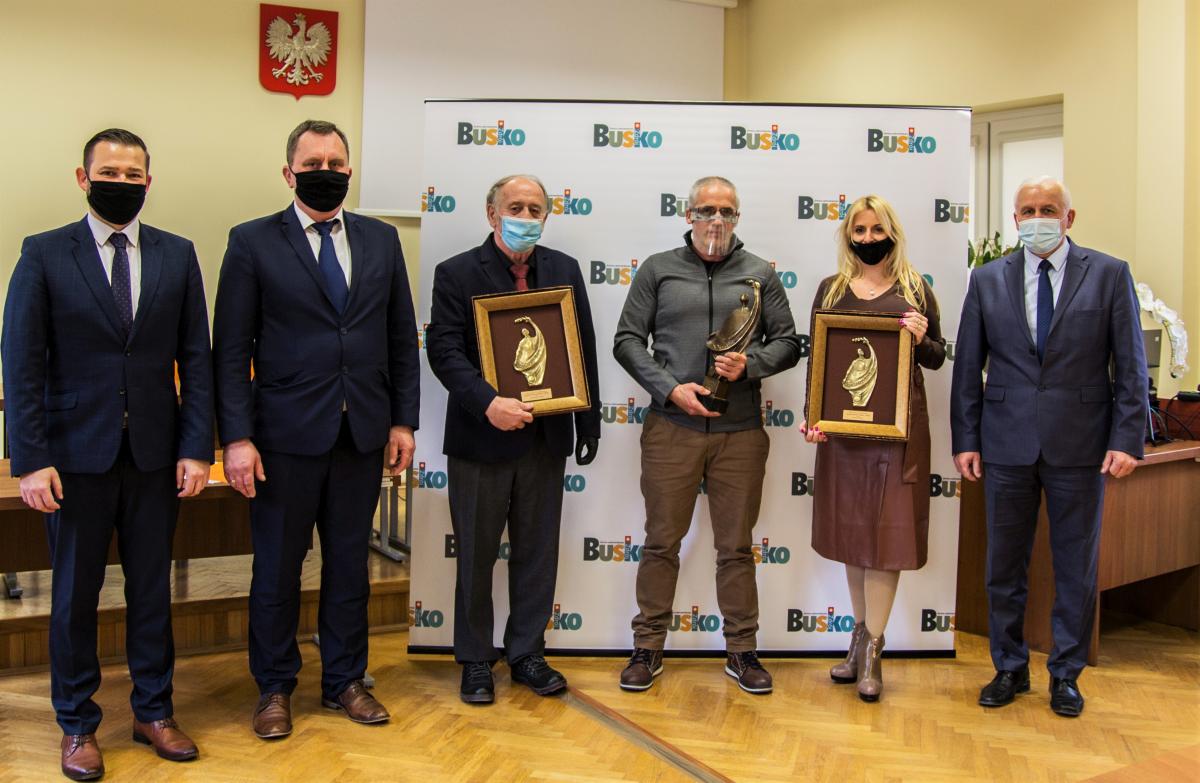 Zdjęcie przedstawia Michała Marońskiego  Zastępcę Burmistrza Miasta i Gminy Busko-Zdrój, Roberta Burchana Przewodniczącego Rady Miejskiej w Busku-Zdroju, Zdzisława Dudka trzymającego wyróżnienie w plebiscycie ,,Buskowianin Roku 2019”, Valerjana Romanovskiego trzymającego statuetkę ,,Buskowianina Roku 2019”, Sylwanę Mazur trzymającą wyróżnienie  w plebiscycie ,,Buskowianin Roku 2019”, Waldemara Sikorę Burmistrza Miasta i Gminy Busko-Zdrój. 