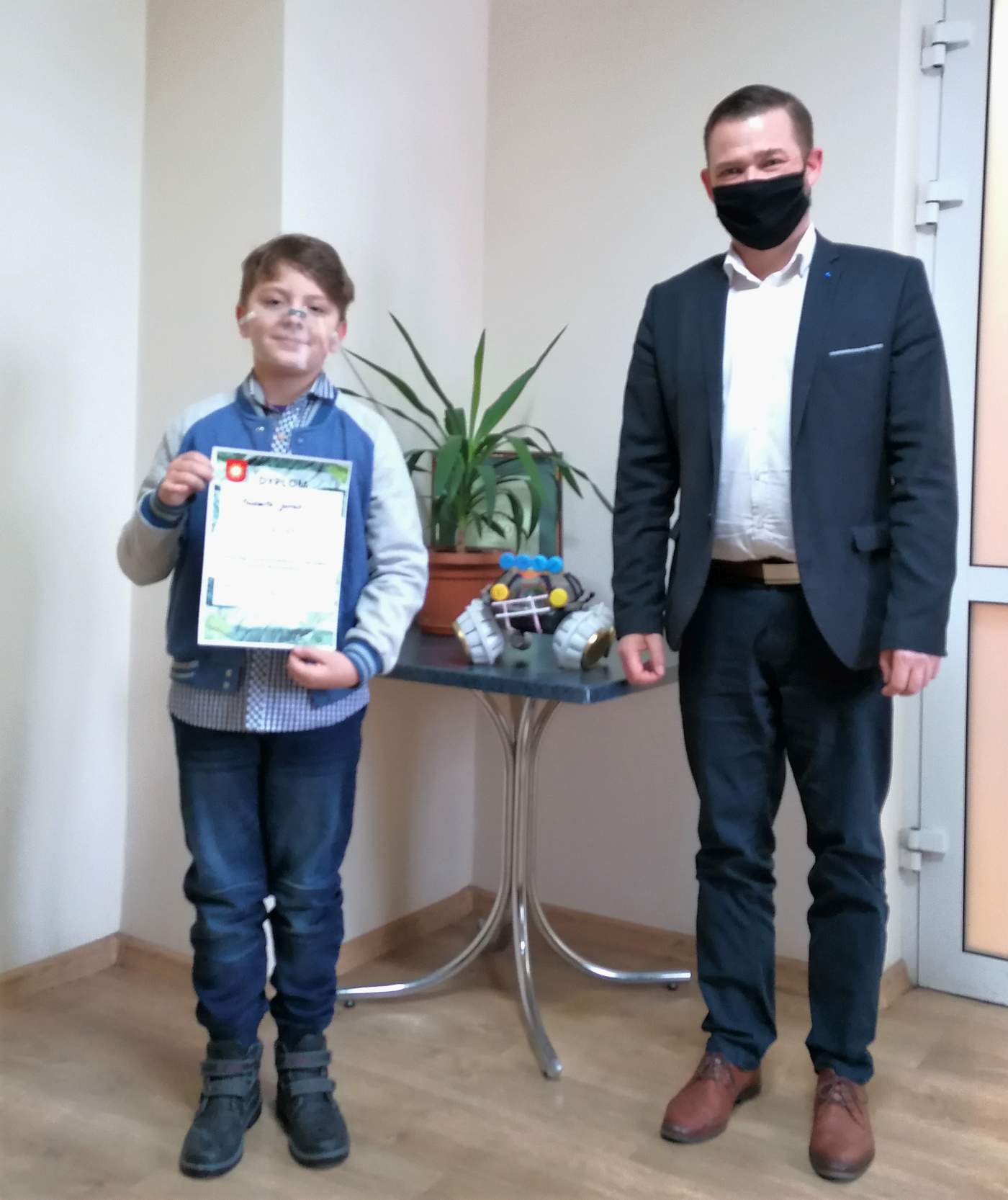Zdjęcie przedstawia Laureata Konkursu trzymającego dyplom wręczony przez Z-cę Burmistrza Miasta i Gminy Michała Marońskiego
