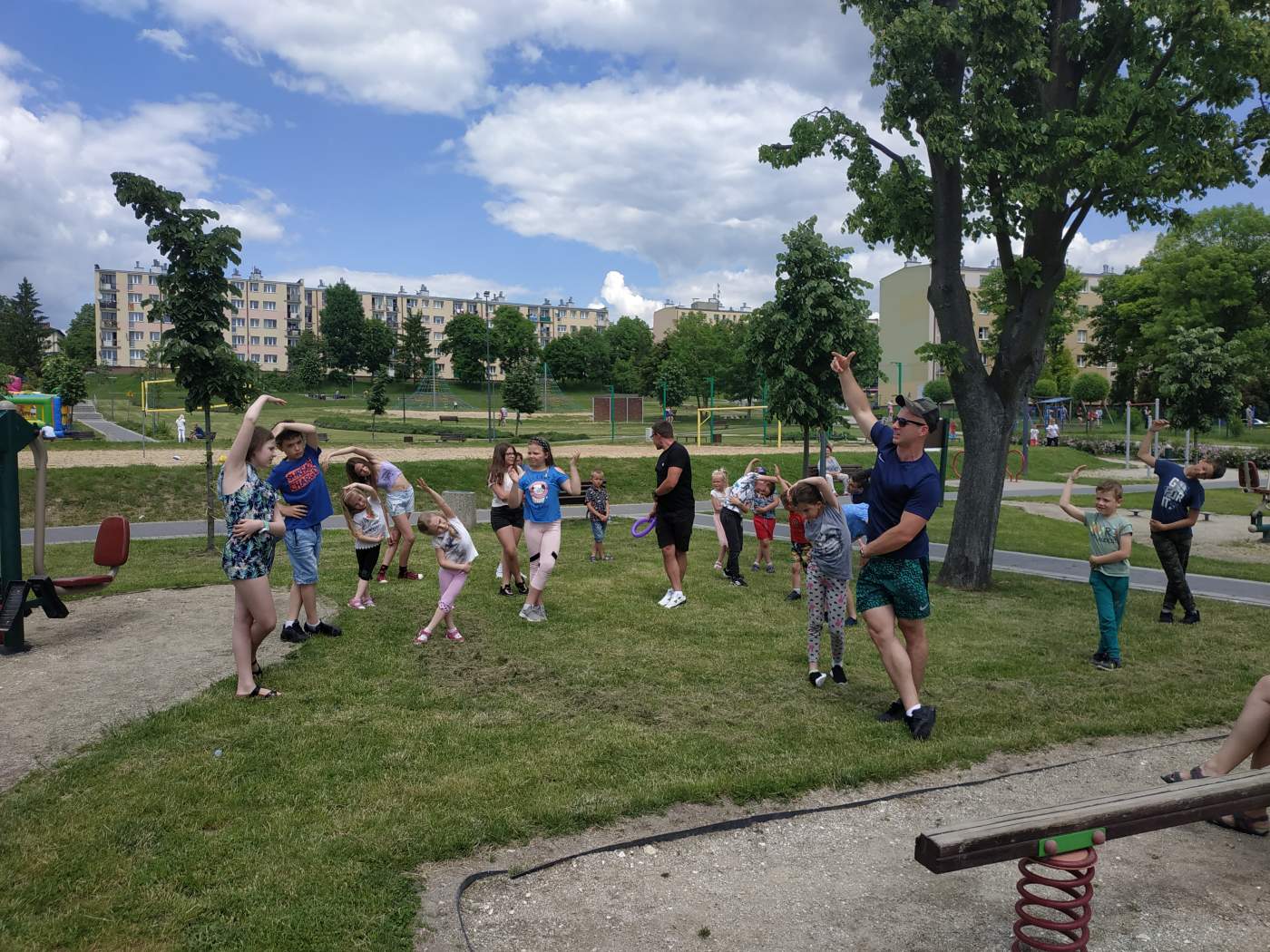 Na zdjęciu widoczni są uczestnicy Festiwalu Rodzinnego ćwiczący pod okiem trenera personalnego.