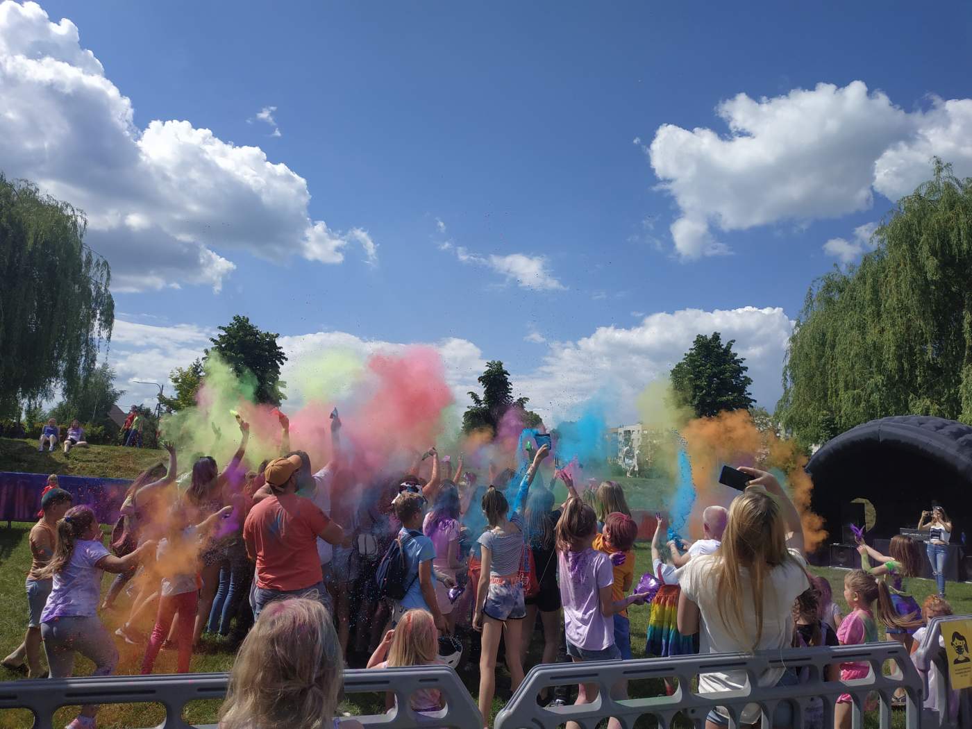 Na zdjęciu widoczni są uczestnicy Holi Święta Kolorów podczas wyrzutu kolorowych proszków holi.
