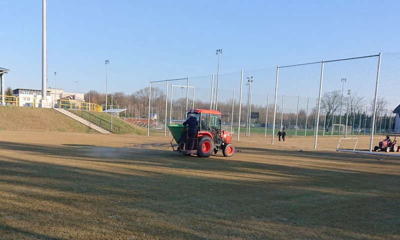 Zdjęcie przedstawia pracowników podczas prac pielęgnacyjnych na stadionie