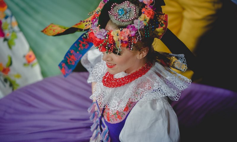 Fotografia przedstawia członkinię zespołu Śląsk w barwnym stroju podczas tańca