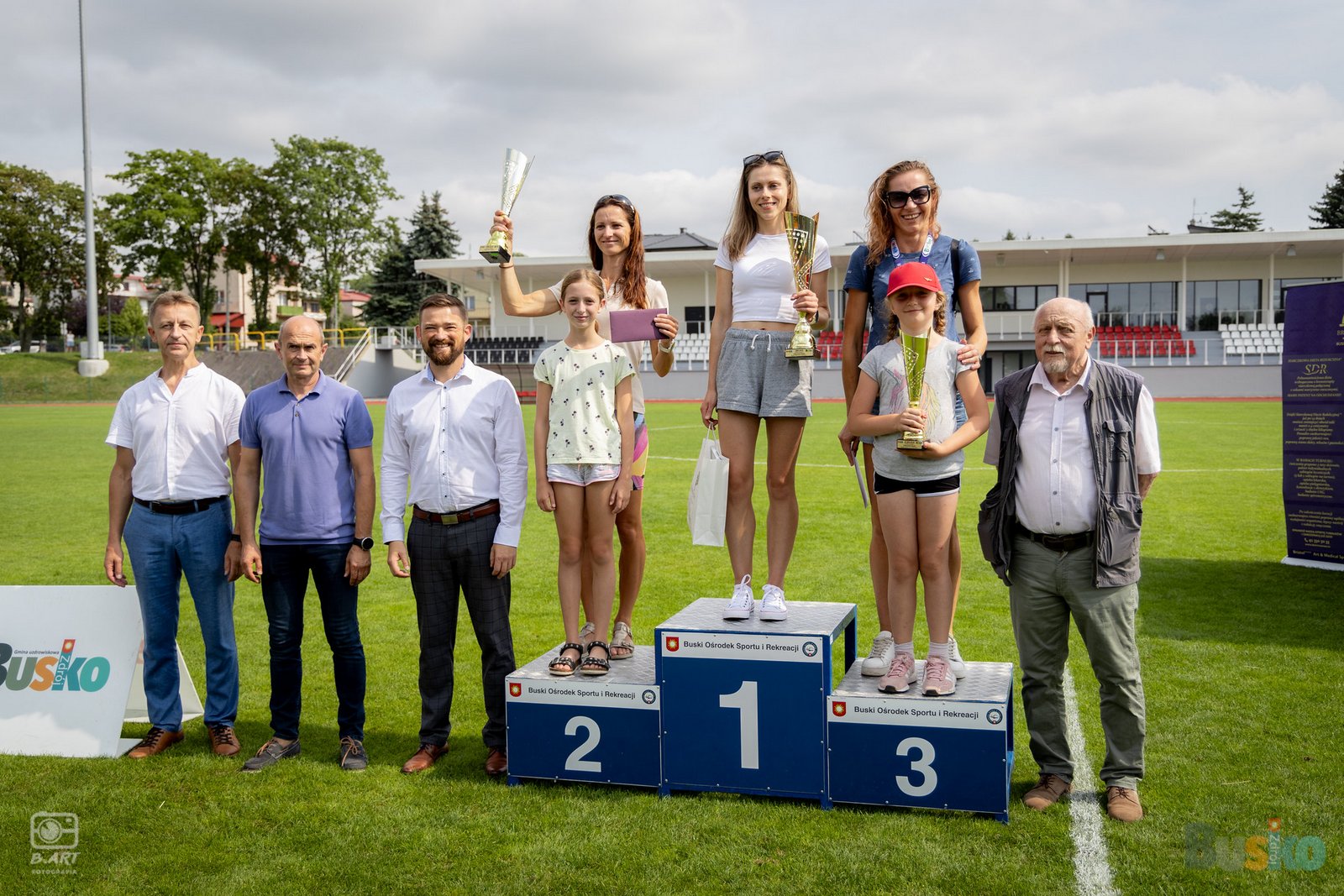 biegacze na podium w towarzystwie organizatorów