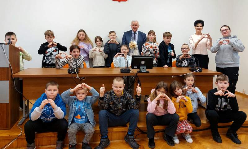 grupa dzieci pozuje do zdjęcia w towarzystwie burmistrza Waldemara Sikory
