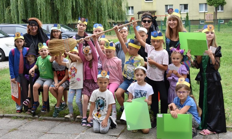 Grupa dzieci i panie pozują do zdjęcia na dworze