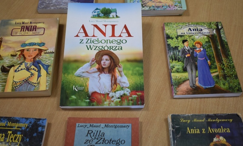 Na stole leżą książki o różnych tutułach z serii o Ani z Zielonego Wzgórza
