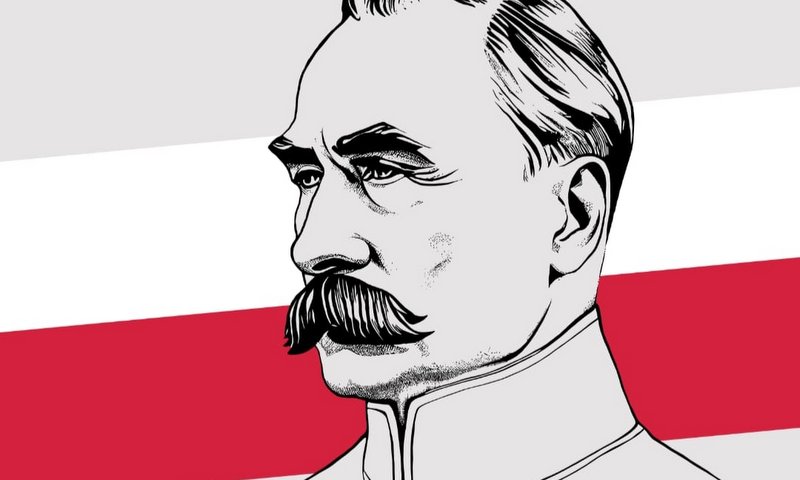 grafika przedstawia Józefa Piłsudskiego na tle polskiej flagi