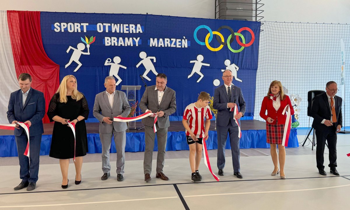 Uroczyste otwarcie hali sportowej w Szańcu, ośmioro osób przecina wstęgę