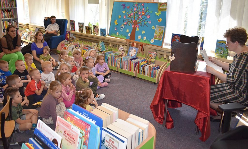 Kobieta czytająca książkę dzieciom