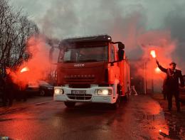 wóz strażacki a w tle race dymne w kolorze czerwonym