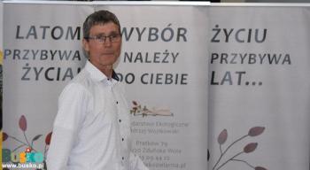 Mężczyzna stoi na tle rollupów promocyjnych