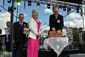 Burmistrz Jerzy Szydłowski kroi dożynkowy chleb, obok Starostowie