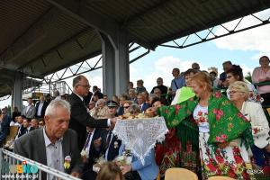 Burmistrz częstuje dożynkowym chlebem zgromadzonych gości