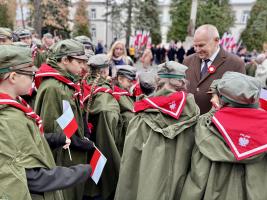 Zastępca Burmistrza częstujący harcerzy cukierkami