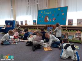 Dzieci siedzą na podłodze i oglądają książki