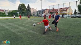 Na zdjęciu znajduje się 9 piłkarzy podających sobie piłkę, biegnących w stronę pola bramkowego.