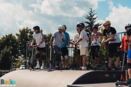 Na zdjęciu widoczni są uczestnicy warsztatów hulajnogi czekający na zjazd z rampy. 