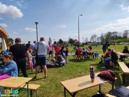 Zdjęcie przedstawia uczestników w trakcie pieczenia kiełbaski