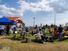 na zdjęciu widoczni są uczestnicy pikniku podczas pieczenia kiełbaski 