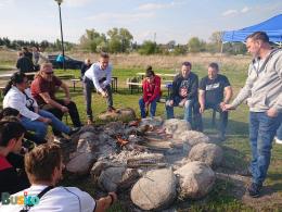 Zdjecie przedstawia uczestników w trakcie pieczenia kiełbaski