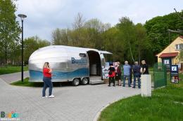 Ludzie oczekujący w kolejce  do kapsuły z kinem sferycznym 