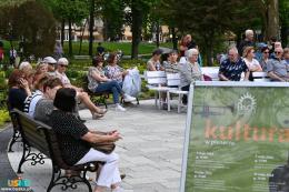 Publiczność siedząca na ławkach przed muszlą koncertową