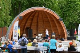 Młody solista z mikrofonem na scenie, na pierwszym planie publiczność 