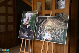 Dwie fotografie na sztalugach przed wejściem do kościoła św. Alberta