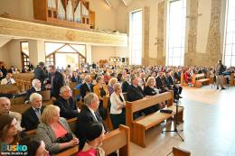 Uczestnicy uroczystości siedzący w ławach kościelnych