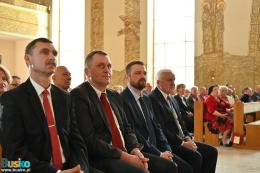 Uczestnicy uroczystości siedzący w ławach kościelnych