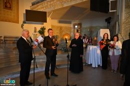 Uroczystość  wręczenia nagrody - burmistrz Sikora i przewodniczący Burchan stoją obok księdza Podymy