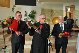 Ksiądz Podyma trzyma statuetkę, obok burmistrz Sikora i przewodniczący Burchan