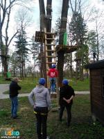 Park linowy Małpi Gaj w Busku-Zdroju - pod drzewami stoi grupa osób w kaskach