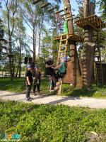 Park linowy Małpi Gaj w Busku-Zdroju - pod drzewami stoi grupa osób w kaskach