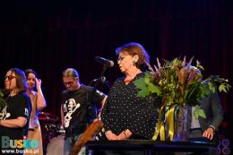 Uroczystość wręczenia nagród. Na pierwszym planie bukiet kwiatów i kobieta