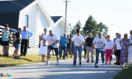 3 zawodników na hulajnogach, w tle publiczność