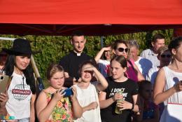 Na zdjęciu osoby obserwujące zmagania sołtysów, pośród nich ksiądz 