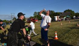 Zawodnik pijący wodę podczas konkurencji powożenia taczkami