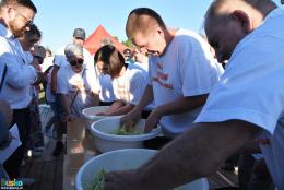 3 zawodników szatkuje kapustę do misek