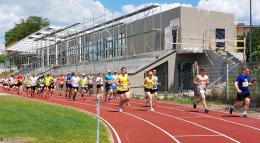 Uczestnicy biegu zdrojowego na bieżni stadionu miejskiego