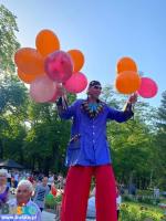 Na zdjęciu szczudlarz z balonami 