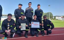 Zwycięska drużyna OSP Szaniec pozuje do zdjęcia z dyplomami 