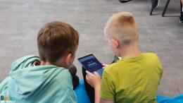 Trwają zajęcia z programowania. Na zdjęciu dwoje dzieci korzystających z aplikacji