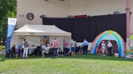 Zdjęcie przedstawia namiot NFZ oraz ludzi korzystających z konsultacji w ramach ,,Pikniku Pokonaj Raka