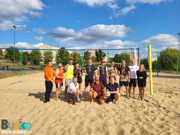 Na zdjęciu widoczni są uczestnicy turnieju towarzyskiego w piłkę siatkową-plażową podczas dekoracji 
