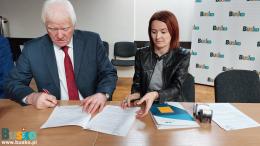 uczestnicy spotkania podpisują dokumenty