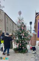 osoby dekorujące świąteczne choinki na placu Zwycięstwa