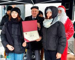 Uczestnicy dekoracji świątecznych wraz z Burmistrzem Waldemarem Sikorą oraz Z-cą Michałem Marońskim  na placu Zwycięstwa