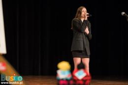 Trwa część artystyczna - na scenie kobieta z mikrofonem